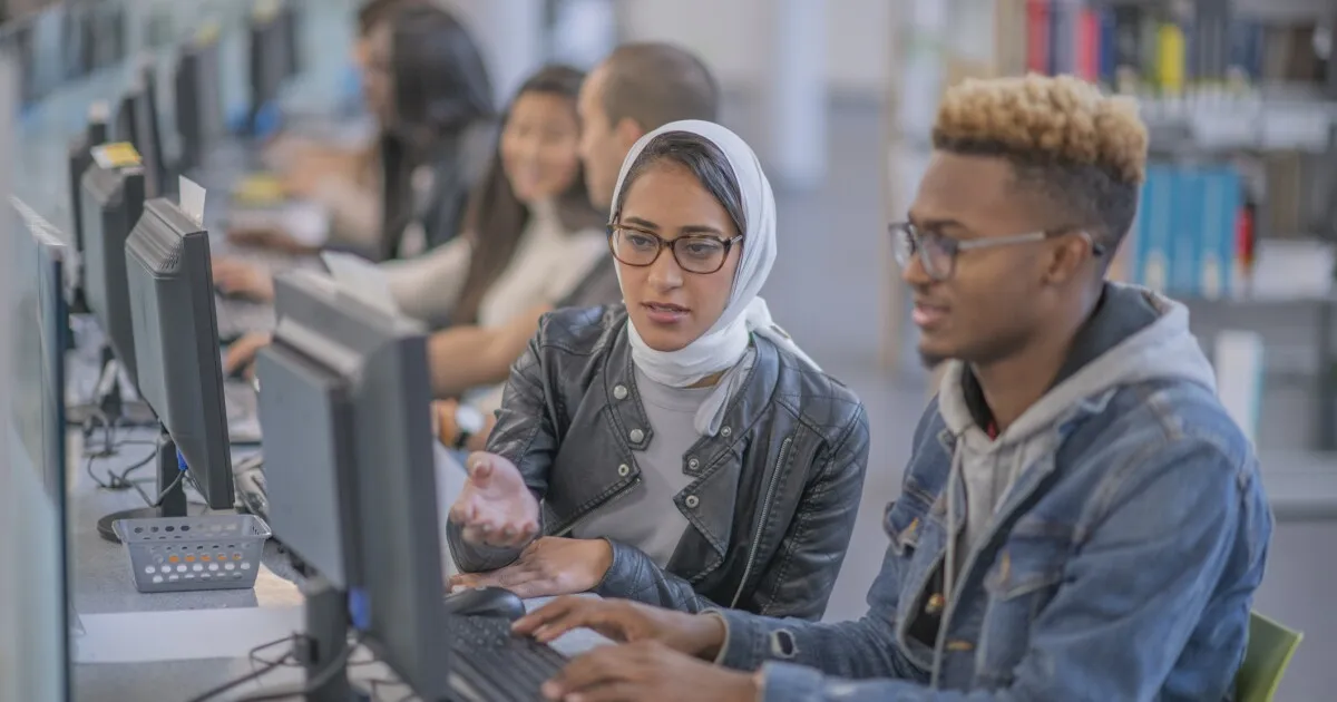 Jovens olhando para telas com expressões de dúvida e preocupação, em ambiente escolar ou de trabalho